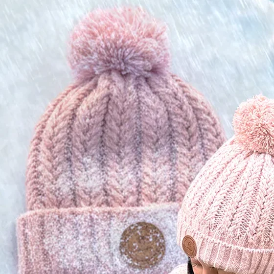 Un bonnet à pompon rose, sous la neige : le produit tel qu’il est vendu.